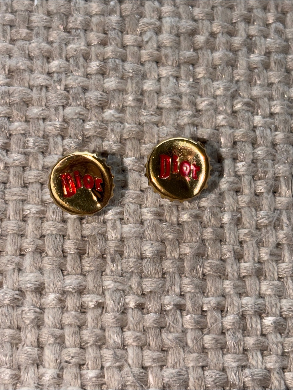 Christian Dior gold-plated crown bottle cap stud earrings featuring a red logo.